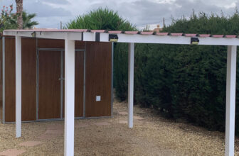 Steel carport with galvanised steel frame and insulated garden storage building installed by The MetalCraftsman